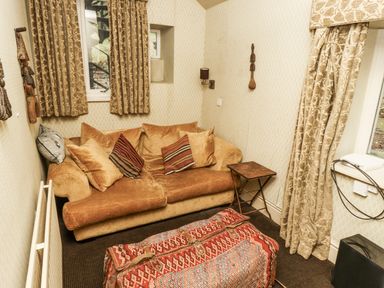 A snug with a sofa and side table at Elford Farmhouse in Seahouses