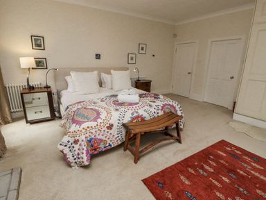 A bedroom with a bed and nightstands at Elford Farmhouse in Seahouses