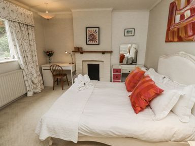 A bedroom with a bed and desk at Elford Farmhouse in Seahouses