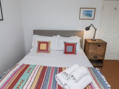 A bedroom with a bed and nightstand at Elford Farmhouse in Seahouses