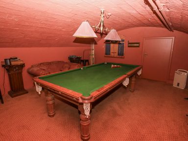 A game room with a billiard table and a couch at Elford Farmhouse in Seahouses