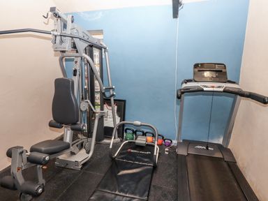 A gym with exercise equipment and a treadmill at Elford Farmhouse Seahouses