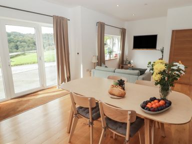 A dining room with a table and chairs at The Lodge in Bridgend