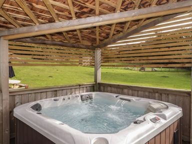 A hot tub in a wooden structure in an outdoor area at The Lodge in Bridgend