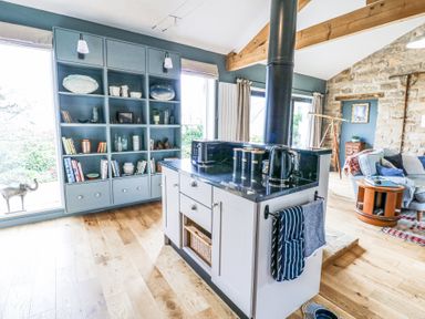 An open kitchen and living area with a blue shelving unit and kitchen island at The Barn in Riding Mill near Corbridge