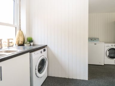 A laundry room with washing machines a sink countertop and plants at The Burleigh in Hunstanton