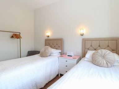 A bedroom with two single beds separated by a white nightstand at The Burleigh in Hunstanton
