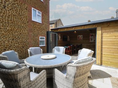 An outdoor garden with a table and chairs at The Burleigh in Hunstanton
