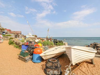 A coastal path with fishing equipment and two white boats near the sea at Moonlight in Ventnor