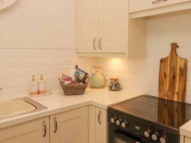 A kitchen with sink stove and kettle at Penwyn in Solva