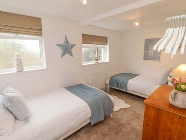 A bedroom with two single beds and a lamp at Penwyn in Solva