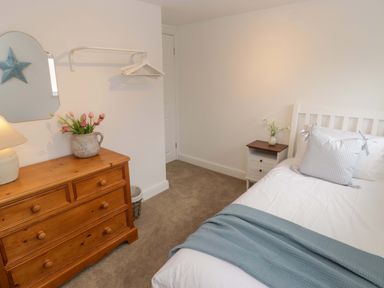 A bedroom with a bed, dresser, and nightstand at Penwyn in Solva