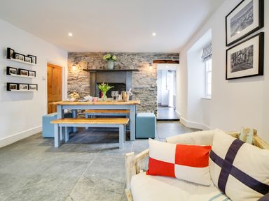 A dining room with a table and bench at Church Hill House in Port Isaac