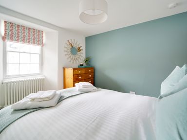 A bedroom with a bed and dresser at Church Hill House in Port Isaac