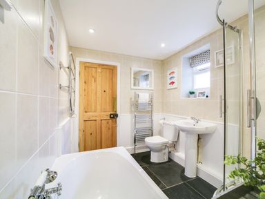 A bathroom with a bathtub and a sink at Church Hill House, Port Isaac