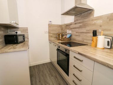 A kitchen with an oven microwave knife block paper towel and spice rack at Gilfach Bach in Dolgellau