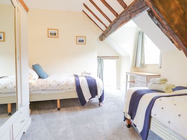 A bedroom with two single beds wooden beams and a desk at Ty Glan Yr Afon in Bontddu near Dolgellau