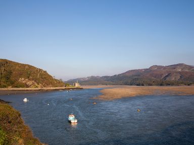 A river with boats and forested hills at Eirlys in Bontddu near Dolgellau