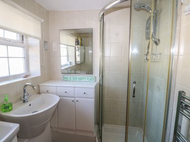 A bathroom with a sink hand wash cabinet mirror and enclosed shower at Kites - 52 Gower Holiday Village in Scurlage near Port Eynon and Rhossili