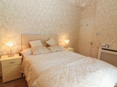 A bedroom with a double bed between two bedside tables with lamps at Killelton Cottage in Camp County Kerry