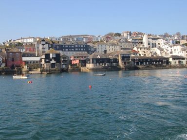 A view of buildings along the waterfront with boats on the water at Tobys Quay in Falmouth