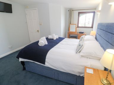 A bedroom with a bed and a desk at Tobys Quay in Falmouth