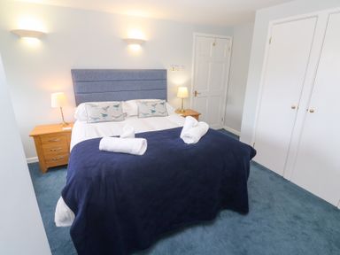 A bedroom with a bed and bedside lamp at Tobys Quay in Falmouth