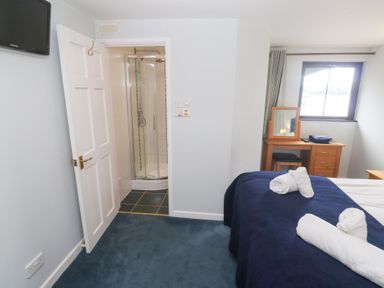 A bedroom with a bed and a shower room at Tobys Quay in Falmouth