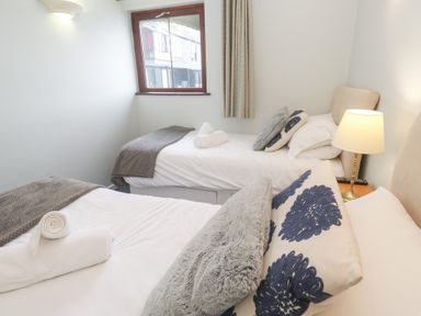 A bedroom with two beds and a lamp at Tobys Quay in Falmouth