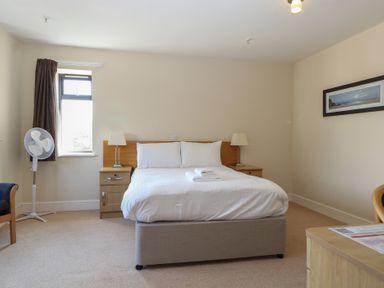 A bedroom with a bed and nightstand at Bedroom 10 in Littlehampton