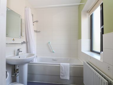 A bathroom with a bathtub and sink at Bedroom 10 in Littlehampton