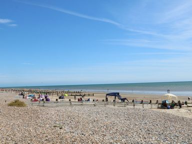 A beach with people and umbrellas at a seaside location in Littlehampton