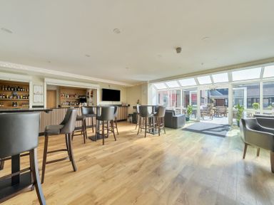 A bar with stools and tables at Marine Court First-floor Double Bedroom with Bathroom in Littlehampton