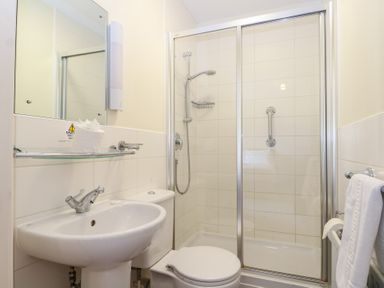 A bathroom with a shower, sink, and toilet at Bedroom 9 in Littlehampton