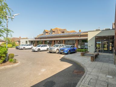 A building with cars parked outside at Marine Court First Floor Double with Shower Room in Littlehampton