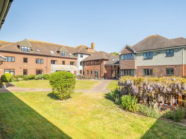 An outdoor view of buildings and a garden at Marine Court First-floor Double Bedroom with Wet Room in Littlehampton