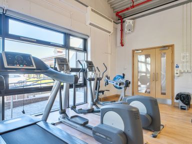 A gym with treadmill, elliptical trainer, and stationary bike at Marine Court First-floor Double Bedroom with Wet Room in Littlehampton