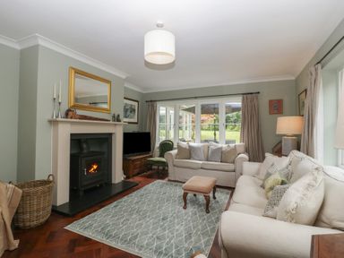 A living room with a fireplace and sofa at St. Marys House in Church Westcote near Bledington
