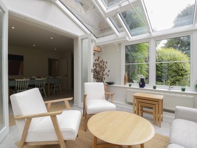A conservatory with chairs and a table at St. Marys House Church Westcote near Bledington