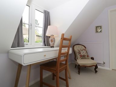 A study with a desk, chair, and lamp at St. Marys House Church Westcote near Bledington