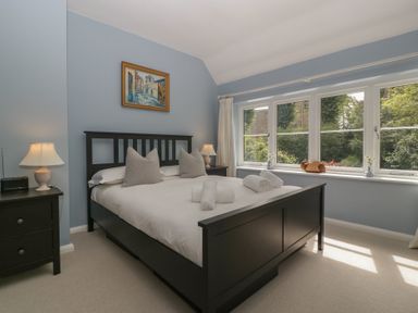 A bedroom with a bed and windows at St. Marys House in Church Westcote near Bledington