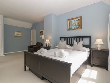 A bedroom with a bed and a chair at St. Marys House in Church Westcote near Bledington