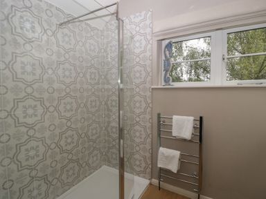 A bathroom with a shower and towel rack at St. Marys House in Church Westcote near Bledington