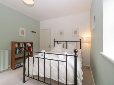 A bedroom with a bed and bookshelf at St. Marys House, Church Westcote near Bledington