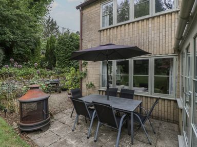 An outdoor patio with a table and chairs at St. Marys House Church Westcote near Bledington