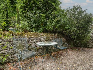 A garden with a table and chairs at St. Marys House in Church Westcote near Bledington