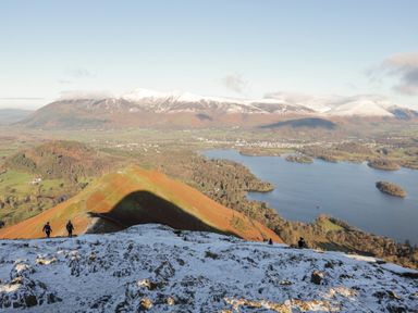 A view from a height showing hikers on a mountain overlooking a lake and fields at Jubilee First-floor Double Bedroom Penrith