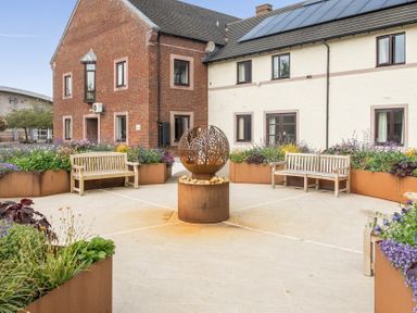 An outdoor garden with benches and a sculpture at Jubilee First-floor Double Bedroom Penrith