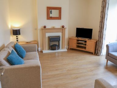 A living room with a sofa and television at Bungalow 15 Eamont Park in Penrith