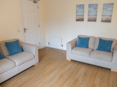 A living room with two sofas and wall art at Bungalow 15 Eamont Park Penrith